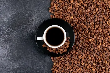 top view coffee cup and coffee beans on dark table